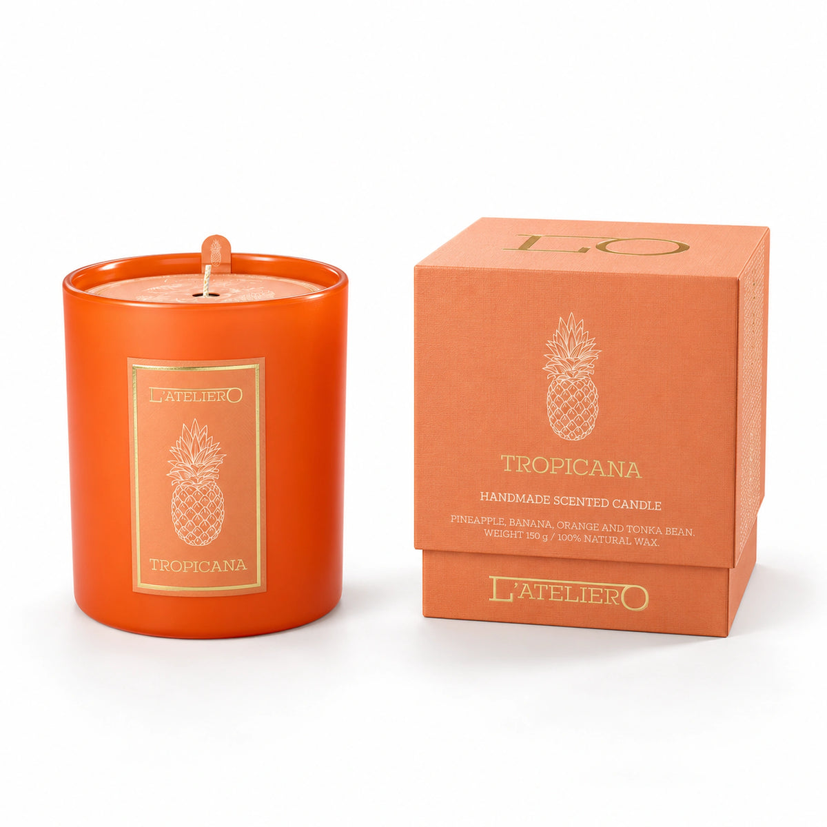L’ATELIERO Tropicana Duftkerze im orangefarbenen Glas neben passender Geschenkbox mit goldener Schrift und Ananas-Motiv auf weißem Grund.